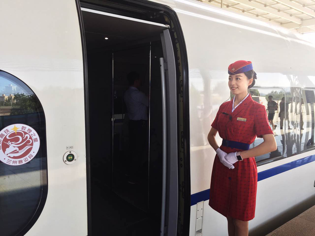 A train attendant ready to welcome passengers on board the first bullet train service to run on the Baoji-Lanzhou high-speed railway at the Baoji South Station, Shaanxi Province, July 9, 2017. [Photo: China Plus]