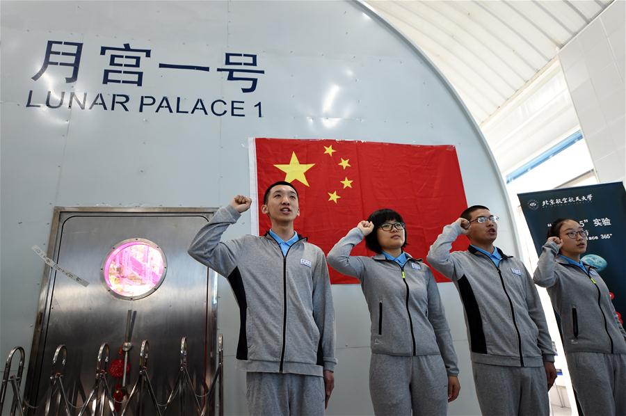 Four volunteers take the oath in front of the Lunar Palace 1, a facility for conducting bio-regenerative life-support systems experiments key to setting up a lunar base, in Beijing University for Aeronautics and Astronautics (BUAA) in Beijing, capital of China, May 10, 2017. [File Photo: Xinhua]