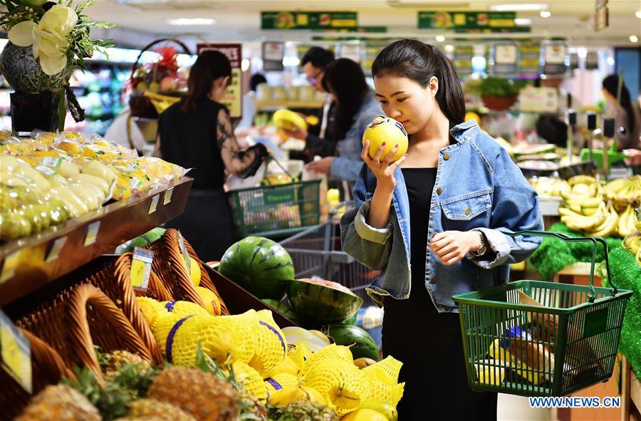 A citizen selects melon at a supermarket in Shijiazhuang, capital of north China's Hebei Province, May 9, 2016. [File photo: Xinhua]