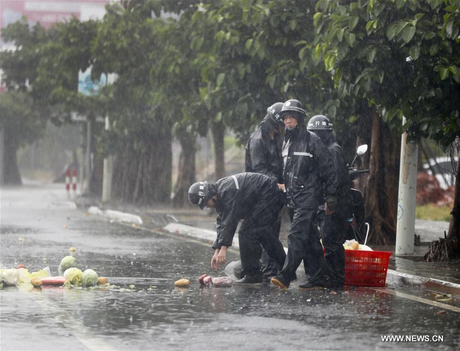Staff members pick up vegetables for a pedestrian in Fuqing City, southeast China's Fujian Province, July 30, 2017. Typhoon Nesat, the ninth typhoon of the year, made landfall in Fujian Sunday morning. Nesat, packing maximum winds of up to 33 meters per second at its center, landed at coastal Fuqing City around 6 a.m. after travelling across Pingtan Island, according to local meteorological authorities. [Photo: Xinhua/Jiang Kehong]