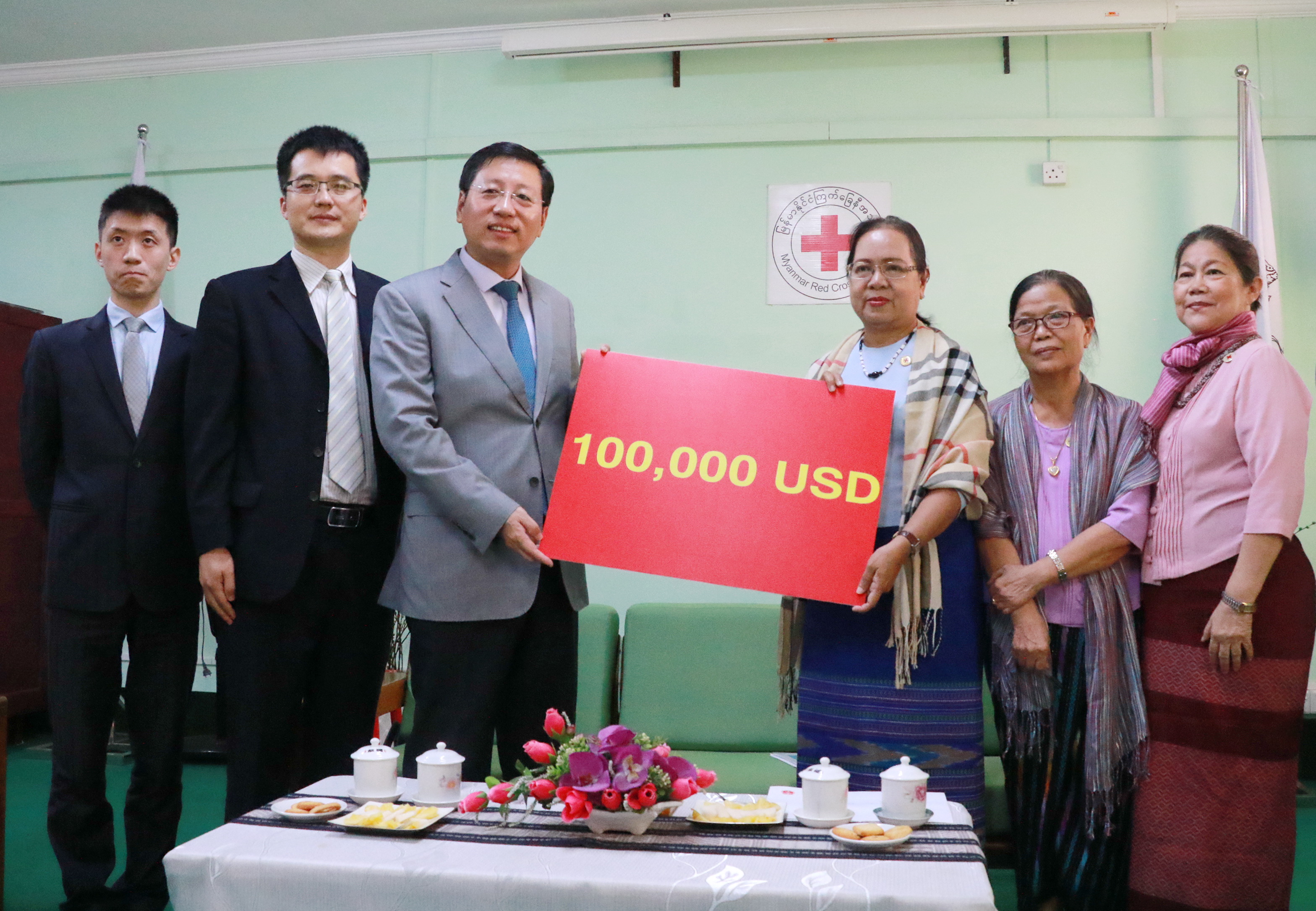 Chinese Ambassador to Myanmar Hong Liang (third from left) handing over the $100,000 provided by the RCSC for emergency flood relief in Myanmar to  Dr. Mya Thu (third from right), Chairwoman of the RSCM, on Monday, August 7th, 2017. [Photo: China Plus/Tu Yun]