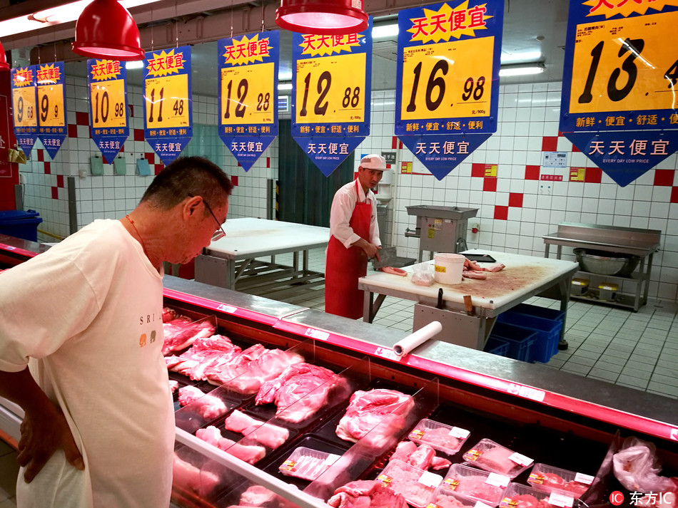 A customer shops for pork at a supermarket in Huaibei City, Anhui province, 7 July 2017. [Photo: IC]