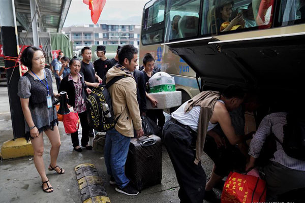 Tourists prepare to get on a bus in the bus station of Pingwu County, Mianyang City of southwest China's Sichuan Province, on August 9, 2017. Over 70,000 people have been evacuated after a 7.0 magnitude earthquake struck Jiuzhaigou County in Sichuan Province on Tuesday and left them stranded. [Photo: Xinhua/Cai Yang]