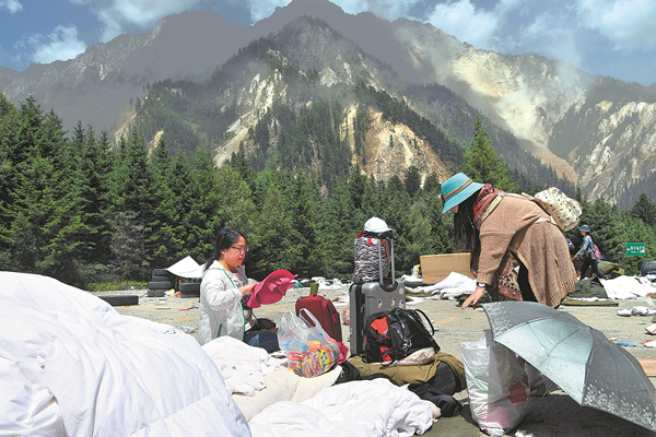 Tourists gather their belongings at a hotel parking lot as they prepare to leave the mountainous earthquake zone on Wednesday, August 9, 2017. [File Photo: Xinhua]
