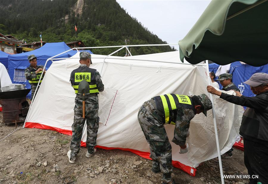Rescuers set up tents for local Tibetan villagers as temporary settlements in Shuzheng Tibetan Village of quake-hit Jiuzhaigou, southwest China's Sichuan Province, Aug. 10, 2017. Temporary settlements were established in Tibetan villages of Jiuzhaigou after a 7.0-magnitude earthquake struck Jiuzhaigou County on Tuesday. Relief supplies have been provided to aid quake-affected people. [Photo: Xinhua/Jiang Hongjing]