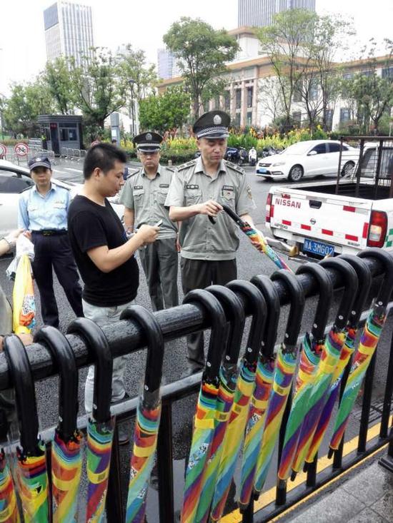 Officers of urban management department remove the sharing umbrellas from public areas in Hangzhou. [Photo: jinbaonet.com]