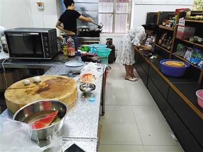 Students cook in the shared-kitchen at Hubei University. [Photo: the Beijing News]