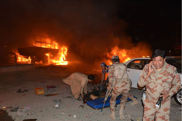 Pakistani soldiers and volunteers attempt to move a victim's body after a blast in Quetta on August 12, 2017. A powerful blast has killed at least 12 people and wounded 20 others in Pakistan's southwestern province of Balochistan. [Photo: CFP]