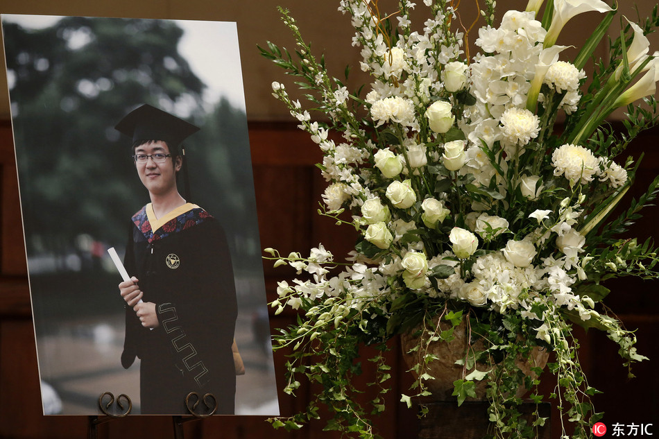 A photo of University of Southern California graduate student Ji Xinran sits next to a flower arrangement during his memorial service at the University of Southern California campus in Los Angeles on Friday, Aug. 1, 2014. Authorities said robbers fatally beat the 24-year old with a baseball bat on July 24 as he walked to his apartment near campus. Four teenagers are charged with murder. Despite his injury, Ji managed to make it home to his apartment, where, police said, a roommate found his body later in the morning. [File Photo: IC]
